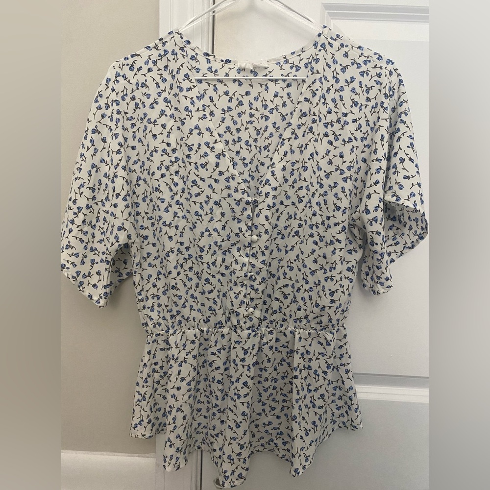 Short sleeve v neck blouse with buttons down front and an elastic cinch at waist